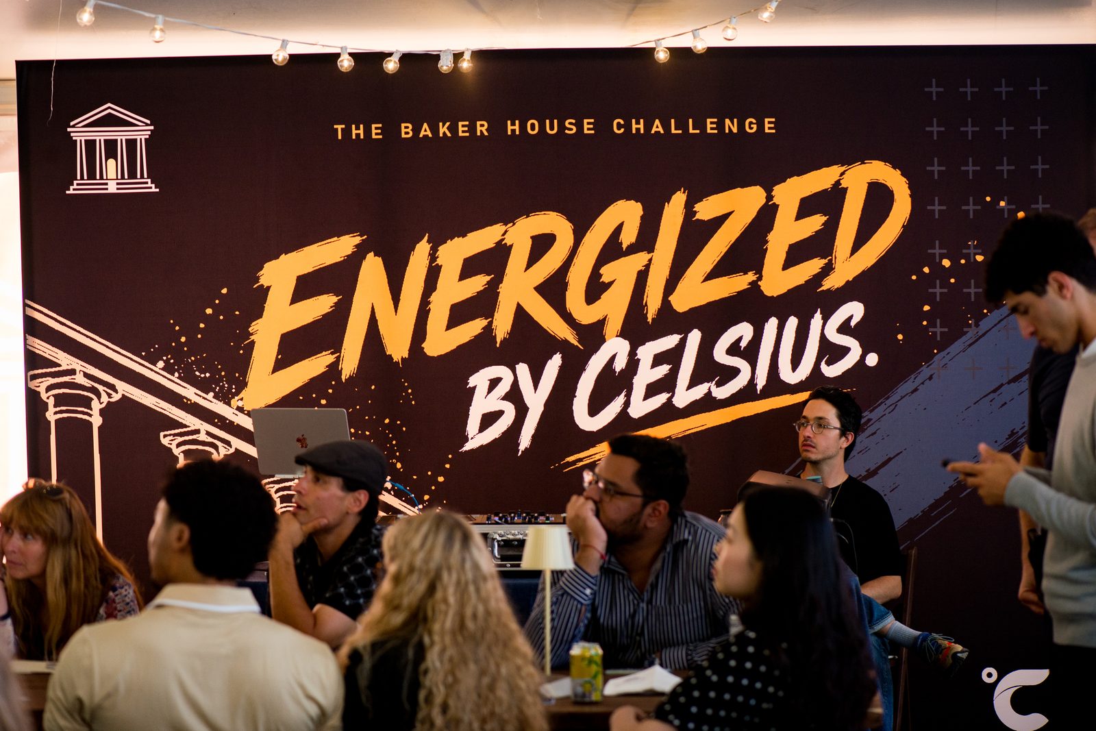 Guests at tables in front of the Baker House Challenge stage backdrop